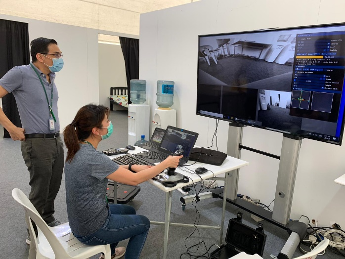 Fig 1: Medical staff learning to navigate robots remotely using DOSS’s remote-control platform at Changi Exhibition Centre (CEC) community isolation   facility.